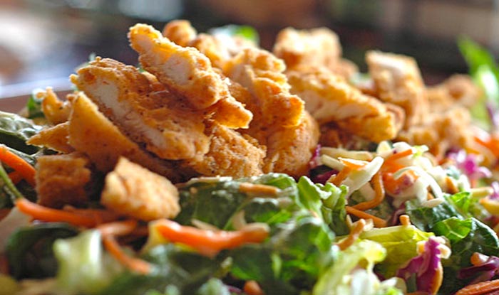 Crispy fried chicken on a fresh mixed green salad at Bricks & Ivy Tavern. Food done right.