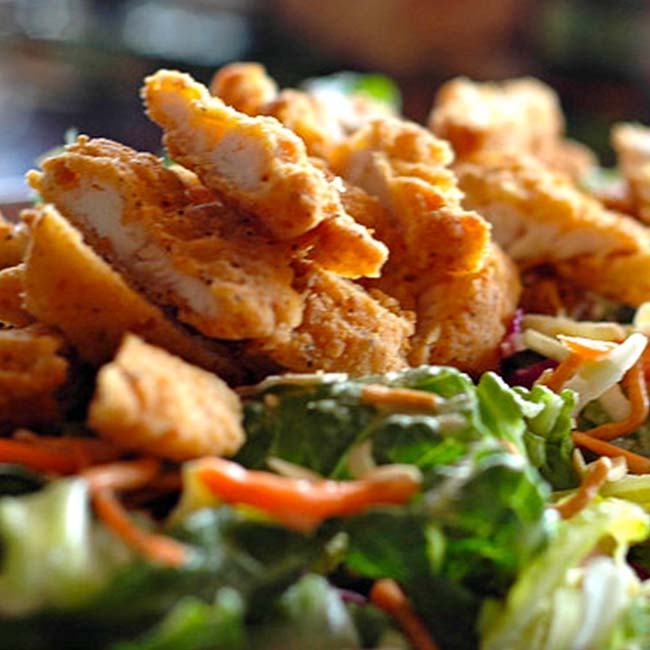 Bricks & Ivy’s crispy fried chicken strips top a fresh green salad in Spring Grove.