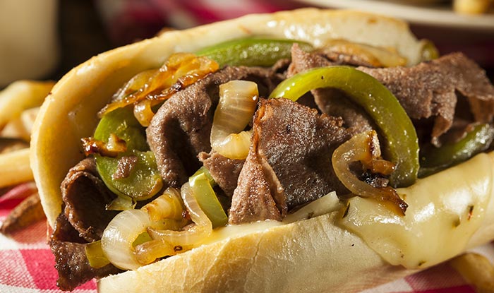 Close-up of a Philly cheesesteak at Bricks & Ivy Tavern with beef, cheese, and grilled onions.